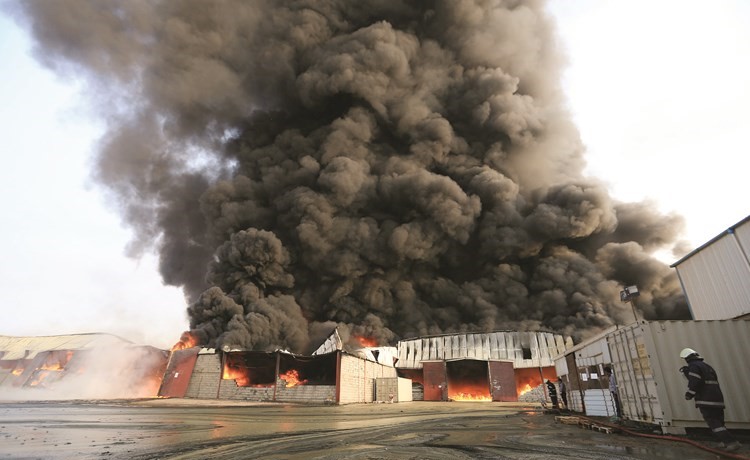 دخان كثيف يتصاعد جراء الحريق الذي التهم المساعدات الغذائية في ميناء الحديدة امس -( رويترز) ﻿