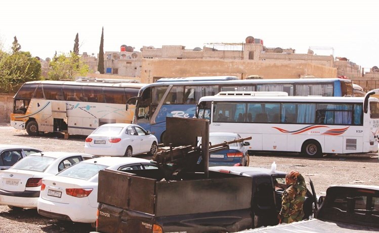 الحافلات تنتظر المهجرين من الغوطة الشرقية لنقلهم شمالا	(رويترز)﻿