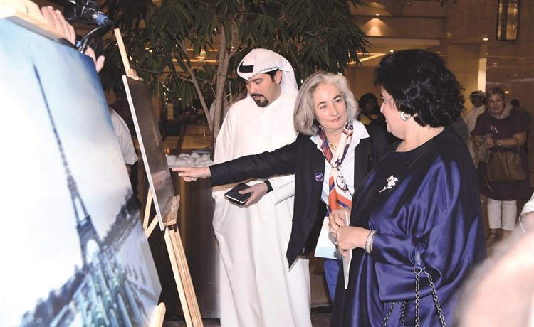 السفيرة الفرنسية ماري ماسدوبوي والشيخة هالة البدر وجابر الهندال يطلعون على إحدى صور المعرض﻿