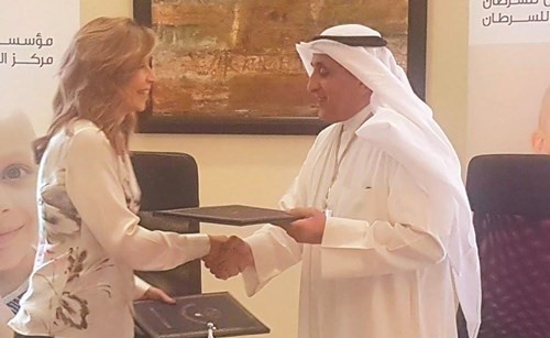 عبدالوهاب البدر مصافحا رئيس هيئة أمناء مؤسسة ومركز الحسين للسرطان الأميرة غيداء طلال عقب توقيع الاتفاقية﻿