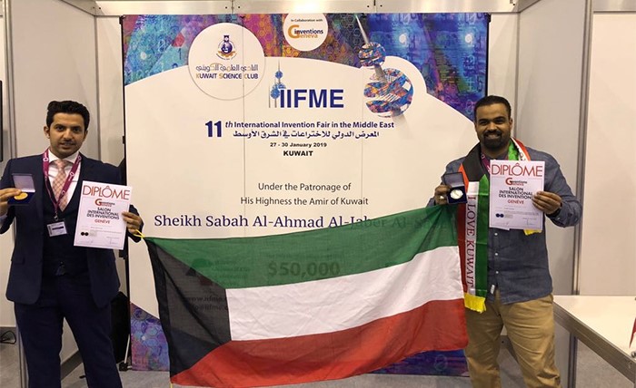 المخترعان د.م.مشاري المطيري وحسين بو مجداد يحملان جائزتيهما الذهبية والفضية مع علم الكويت