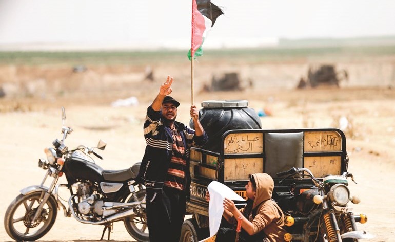 فلسطيني يتحدى آليات الاحتلال ويرفع العلم واشارة النصر علىحدود قطاع غزة	(أ.ف.پ) ﻿
