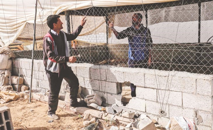 فلسطينيان يتفقدان منزلهما في خان يونس شرقي غزة بعد قصفه من قبل الاحتلال أمس	(أ.ف.پ) ﻿