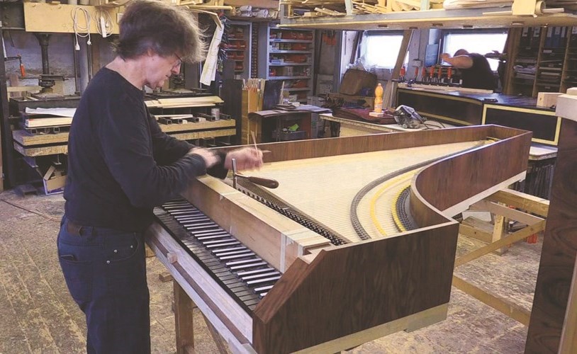بول ماكنولتي يعمل على صناعة إحدى آلات البيانو﻿