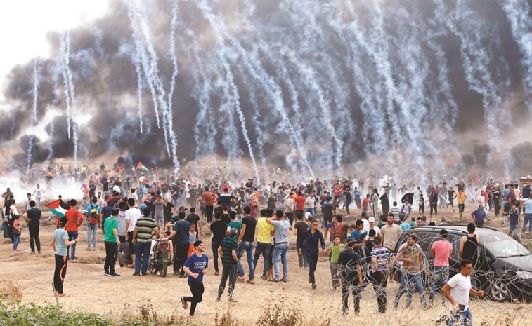 قنابل الاحتلال المسيلة للدموع تتساقط على المحتجين الفلسطينيين على طول الحدود مع قطاع غزة أمس	(أ.ف.پ)﻿
