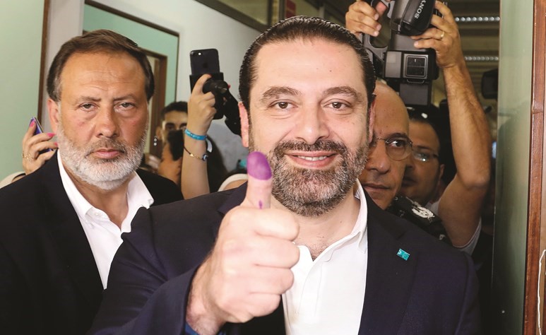 رئيس الحكومة سعد الحريري رافعا اصبعه المصبوغ بعد الاقتراع﻿