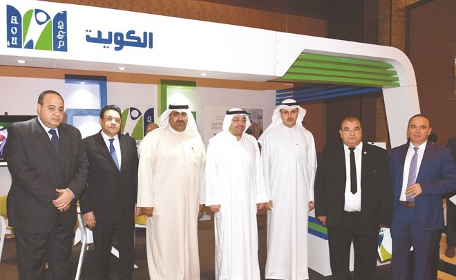 د.صبيح المخيزيم ويوسف خالد المرزوق والسفير طارق القوني أمام جناح الجامعة العربية المفتوحة بالمعرض﻿