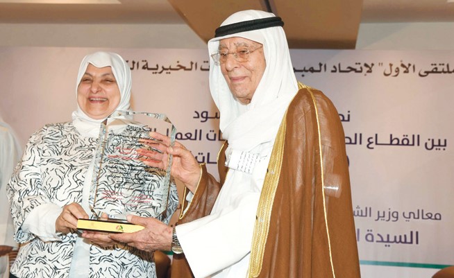 الوزيرة هند الصبيح تتسلم درعا تذكارية من رئيس اتحاد الجمعيات والمبرات الخيرية خالد العيسى الصالح  (محمد هاشم)