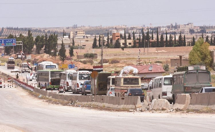 قافلة المهجرين من بلدات يلدا وببيلا وبيت سحم لدى وصولها الى مدخل حلب في طريقها الى الباب وجرابلس	(أ.ف.پ)﻿