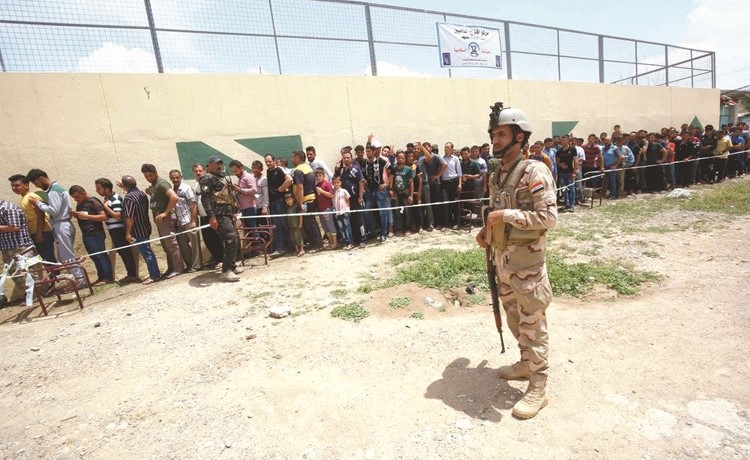عراقيون يصطفون في طابور بانتظار الادلاء بأصواتهم في الانتخابات بالموصل امس	 (أ.ف.پ)﻿