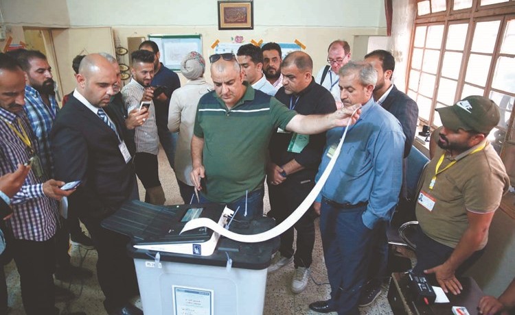 موظف المفوضية العليا للانتخابات يغلق صندوق اقتراع بإحدى لجان بغداد	(رويترز)﻿