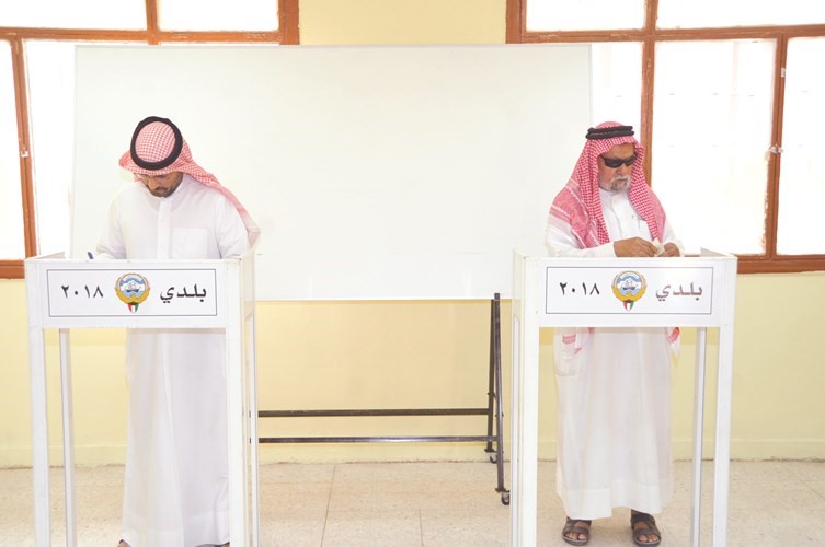 ناخبان خلال الإدلاء بصوتيهما في إحدى اللجان بالدائرة السادسة ﻿