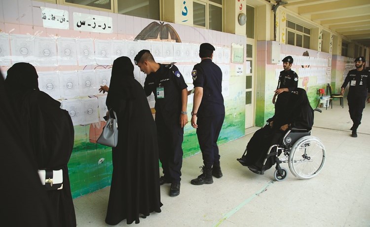 رجال الشرطة يساعدون عددا من السيدات في البحث عن قيدهن الانتخابي ﻿