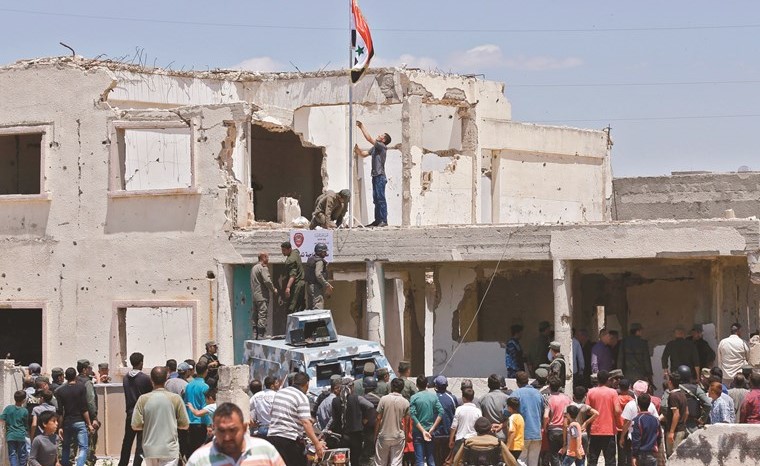 قوات النظام ترفع العلم في مدينة تلبيسة بمحافظة حمص بعد خروج آخر مقاتلي المعارضة منها-(أ.ف.پ)﻿