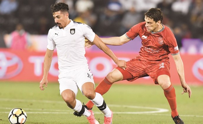 مهاجم السد بغداد بونجاح يحاول المرور من مدافع الدحيل لوكاس﻿
