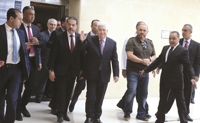 الرئيس الفلسطيني محمود عباس ملوحا بيده خلال مغادرته المستشفى في رام الله امس-(أ.ف.پ) ﻿