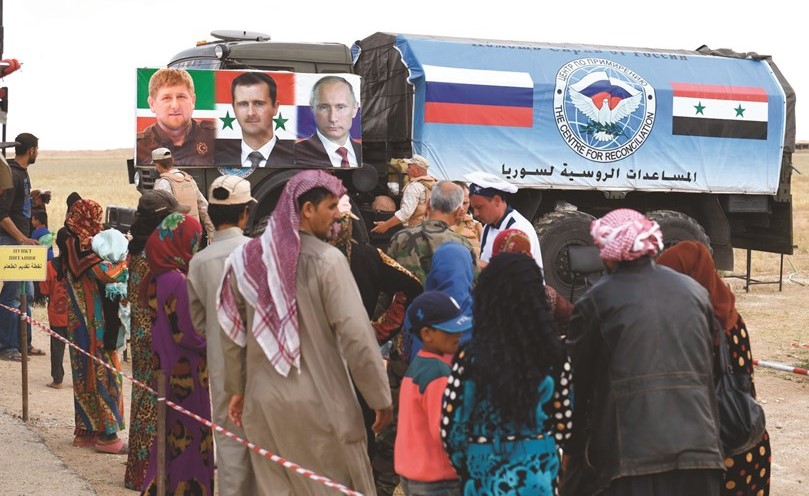 الشرطة العسكرية الروسية تقدم طعاما لسوريين عائدين الى مناطقهم في أبو الظهور بريف إدلب	(أ. ف. پ) ﻿