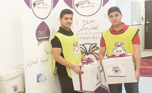 فريق العمل خلال توزيع السلال الرمضانية﻿