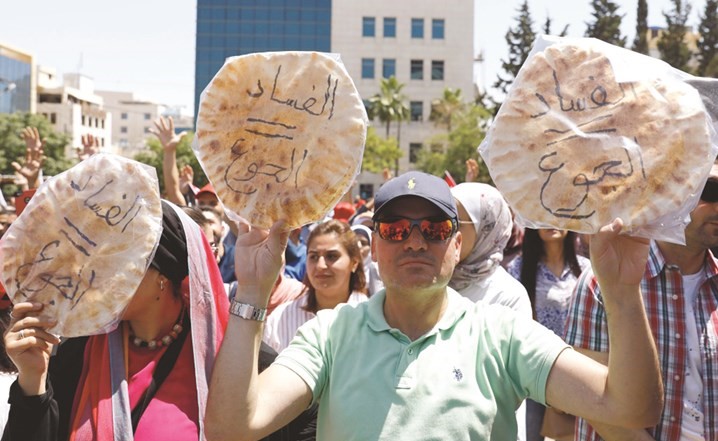 محتجون أردنيون يرفعون أرغفة خبز تزامنا مع إضراب ضد مشروع قانون ضريبة الدخل في عمان امس	(ا.ف.پ)﻿