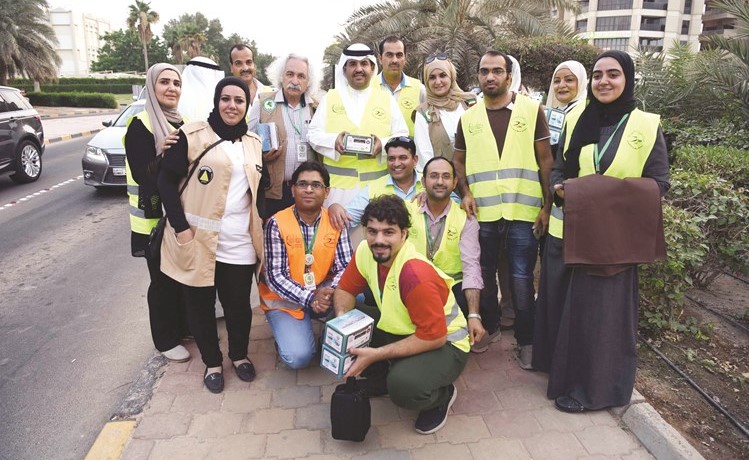 الشيخ دعيج الخليفة متوسطا عددا من أعضاء مركز العمل التطوعي المشاركين في رمضان أمان ﻿