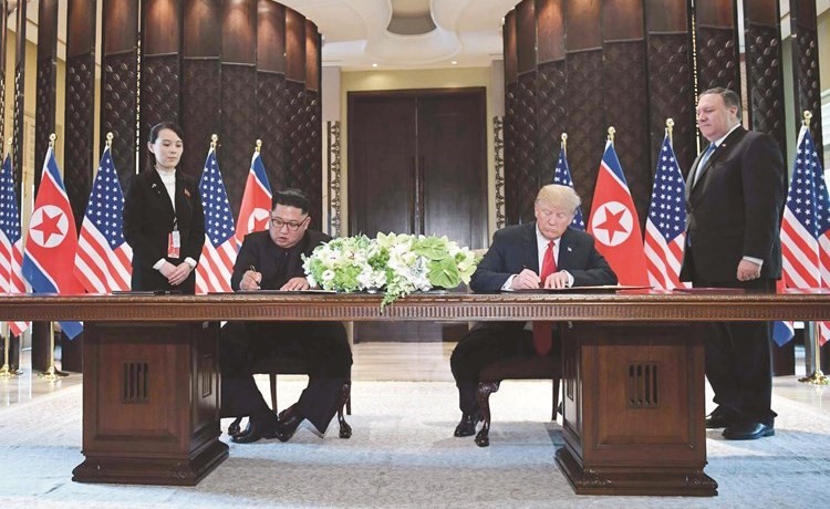  ﻿الرئيس الأميركي دونالد ترامب وزعيم كوريا الشمالية كيم جونغ أون يوقعان على الوثيقة المشتركة خلال قمتهما في سنغافورة أمس 	(رويترز)﻿