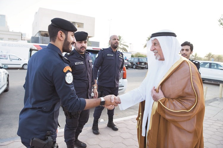 عبدالعزيز الغنام مصافحا رجال الشرطة أمام مسجد فاطمة في ضاحية عبدالله السالم ﻿