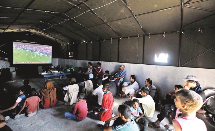 لاجئون سوريون يتابعون مباريات كأس العالم في مخيم عين عيسى في الرقة	(أ.ف.پ)﻿