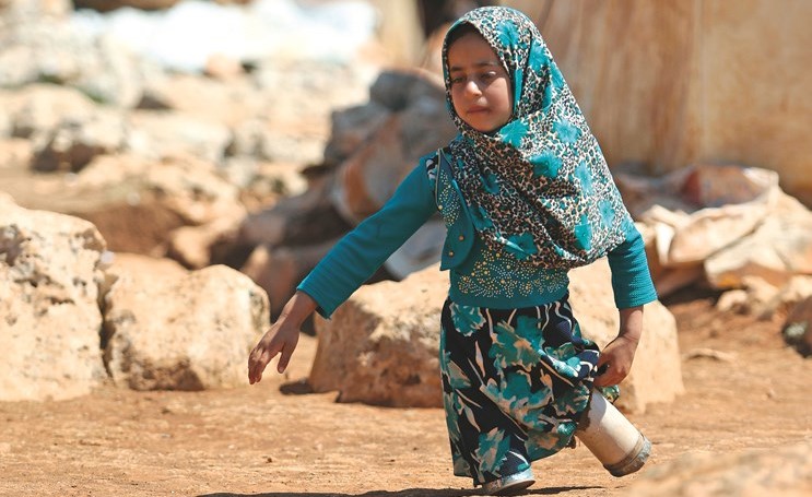 الطفلة مايا ذات الثماني أعوام حرمتها الغارات من ساقيها فصنع لها والده ارجلا من العلب المعدنية في إدلب- (أ.ف.پ)﻿