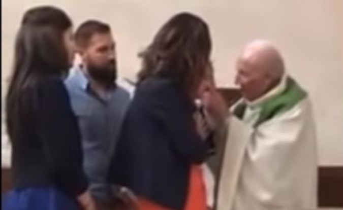 بالفيديو.. قس يصفع رضيعاً رفض التوقف عن البكاء أثناء تعميده يثير الجدل