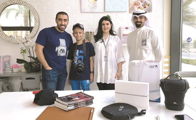 فريق البنك الوطني مع المصور عبدالعزيز السريع والطفل عبدالله ﻿