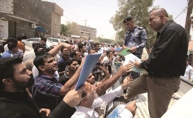 عراقيون يقدمون طلبات توظيف الى مندوبين عن الحكومة في البصرة امس الاول	(رويترز) ﻿
