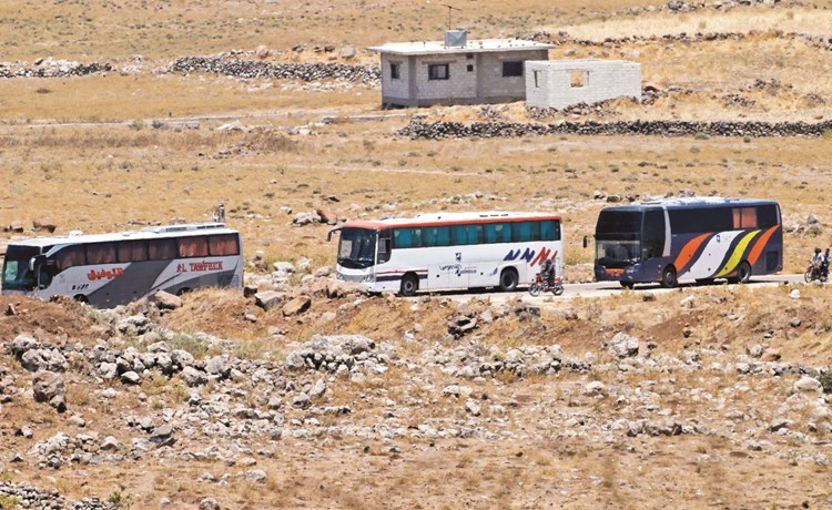 حافلات في طريقها لبدء عملية الإجلاء من القنيطرة إلى إدلب أمس 	(أ.ف.پ)﻿