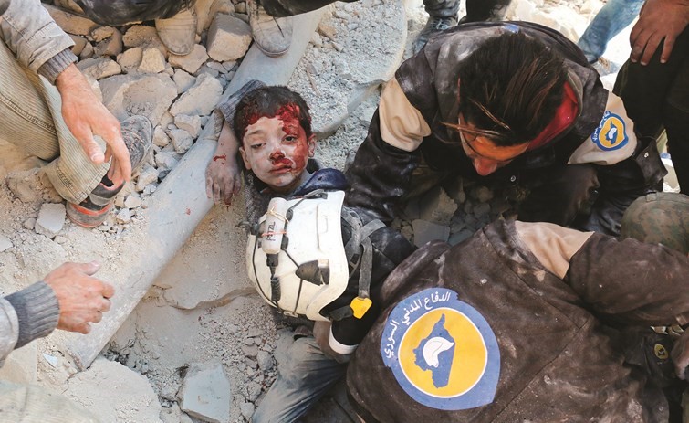 صورة ارشيفية لعناصر من الخوذ البيضاء ينقذون طفلا من تحت الدمار في حلب	(أ.ف.پ)﻿