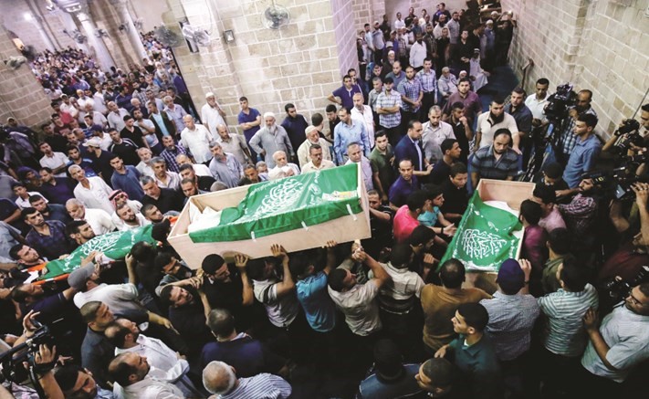 فلسطينيون خلال تشييعهم أمس جثامين الشهداء الثلاثة الذين قضوا في قصف اسرائيلي	(ا.ف.پ) ﻿