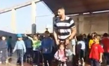 بالفيديو.. مشهد مؤثر لمدرس يحمل طفلة "قعيدة" كي ترقص مع صديقاتها