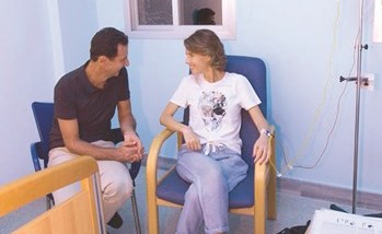 صورة وزعتها سانا للرئيس بشار الاسد بجانب زوجته في المستشفى حيث تتلقى علاجا من السرطان(رويترز) ﻿