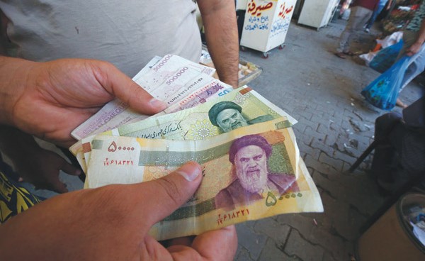 صراف عراقي يعرض عملة إيرانية للبيع في بغداد(أ.ف.پ)