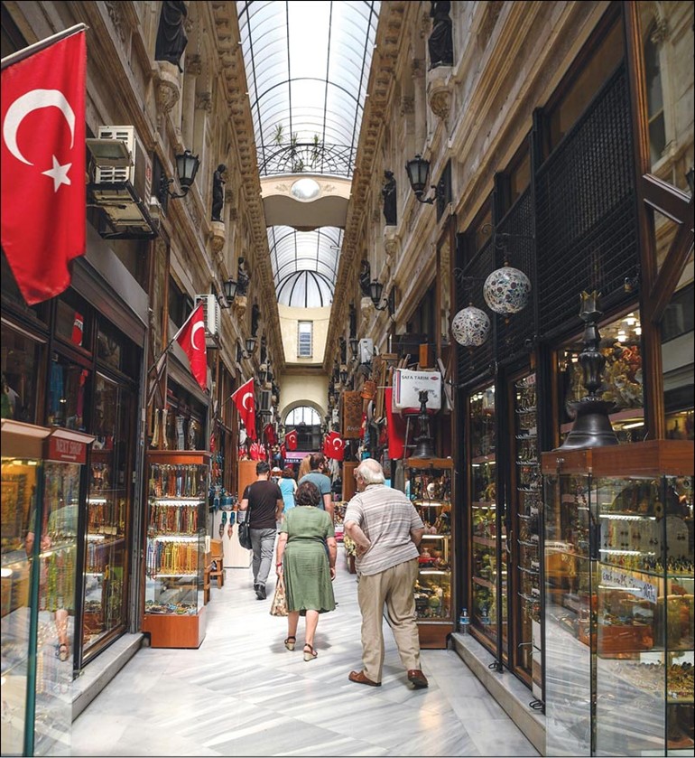 سائحون من أوروبا يتجولون في أحد الأسواق التركية في إسطنبول أمس 	(ا.ف.پ)