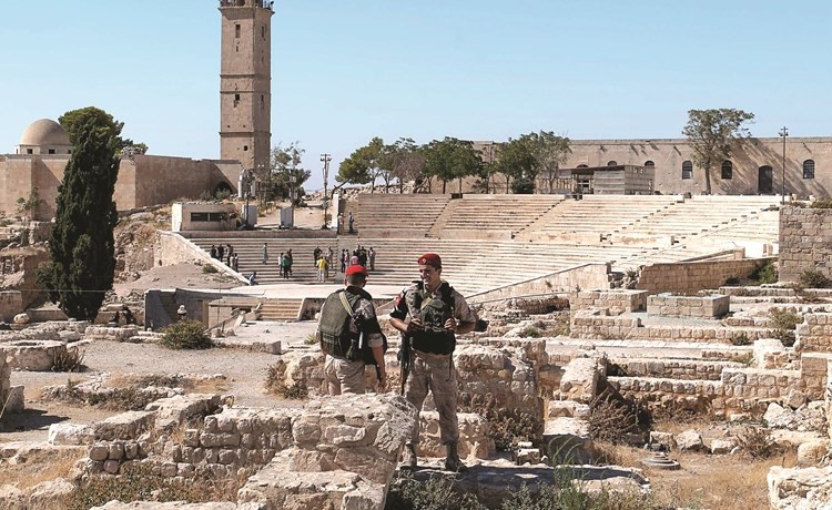 عنصران من القوات الروسية يقومان بحماية قلعة حلب الاثرية	(أ.ف.پ)﻿