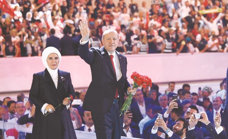 اردوغان والى جواره زوجته يحيي أعضاء حزبه خلال اعمال مؤتمره السنوي في انقرة امس ﻿