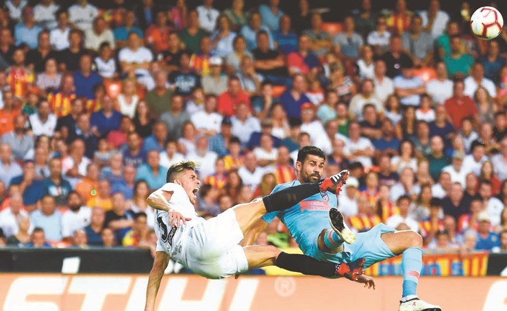 مهاجم أتلتيكو دييغو كوستا في صراع على الكرة مع لاعب فالنسيا غابرييل باوليستا