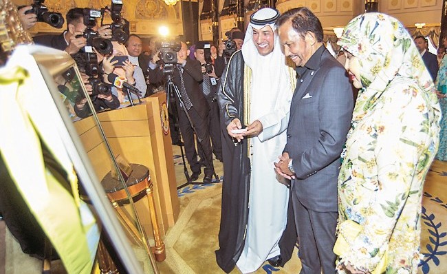 د. فهد الظفيري خلال تقديم الهدايا التذكارية إلى السلطان حسن البلقية﻿