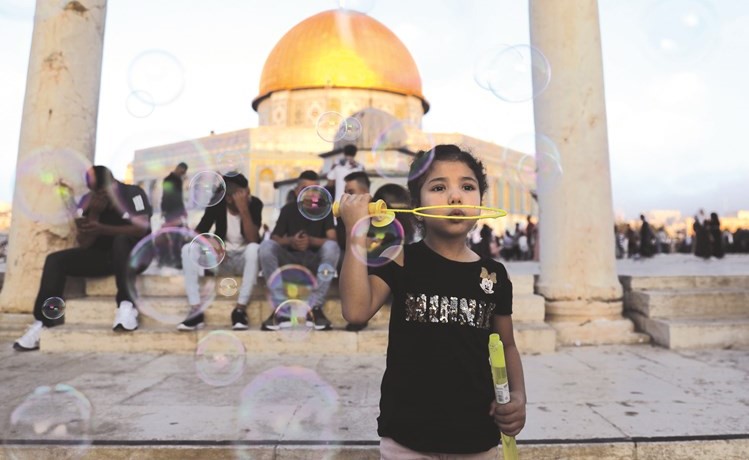 طفلة فلسطينية تنفخ فقاعات الصابون امام قبة الصخرة في القدس المحتلة	(أ.ف.پ)﻿