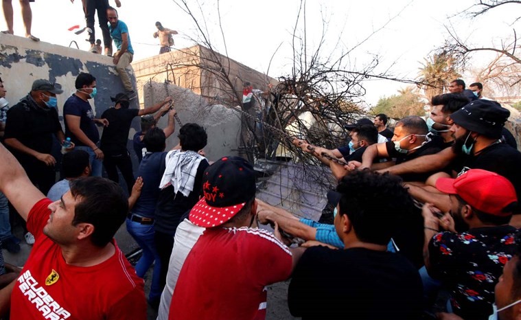 متظاهرون يزيلون الجدران الأسمنتية حول احد المباني الحكومية في البصرة	(رويترز)﻿
