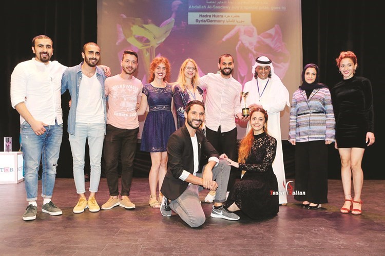 مدير المهرجان خالد الرويعي يسلم جائزة لأحد الفائزين خلال حفل ختام المهرجان﻿