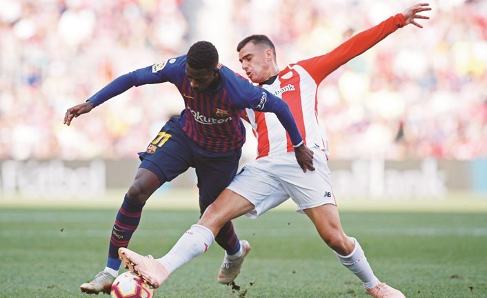 لاعب برشلونة عثمان ديمبلي يحاول المرور من لاعب بلباو ﻿