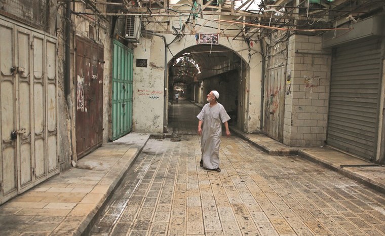 فلسطيني يمر أمام المحلات المغلقة خلال الإضراب العام في نابلس امس	 (ا.ف.پ)﻿