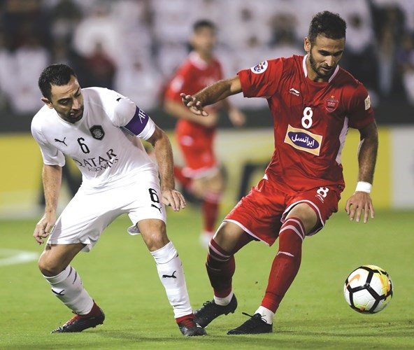 تشافي يحاول استخلاص الكرة من لاعب بيروزي﻿