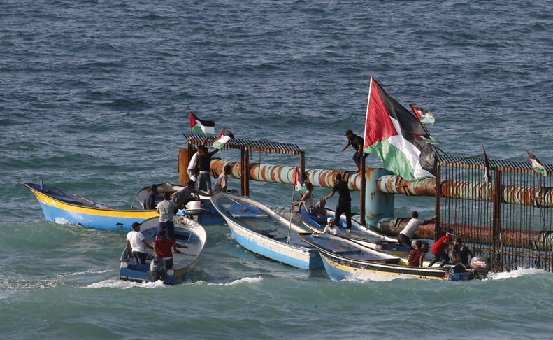 فلسطينيون يغرسون العلم الفلسطيني على الحدود البحرية لقطاع غزة	 (أ.ف.پ)﻿