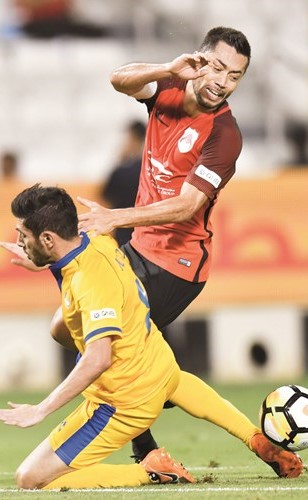 لاعب الريان تاباتا يحاول المرور من مدافع الغرافة